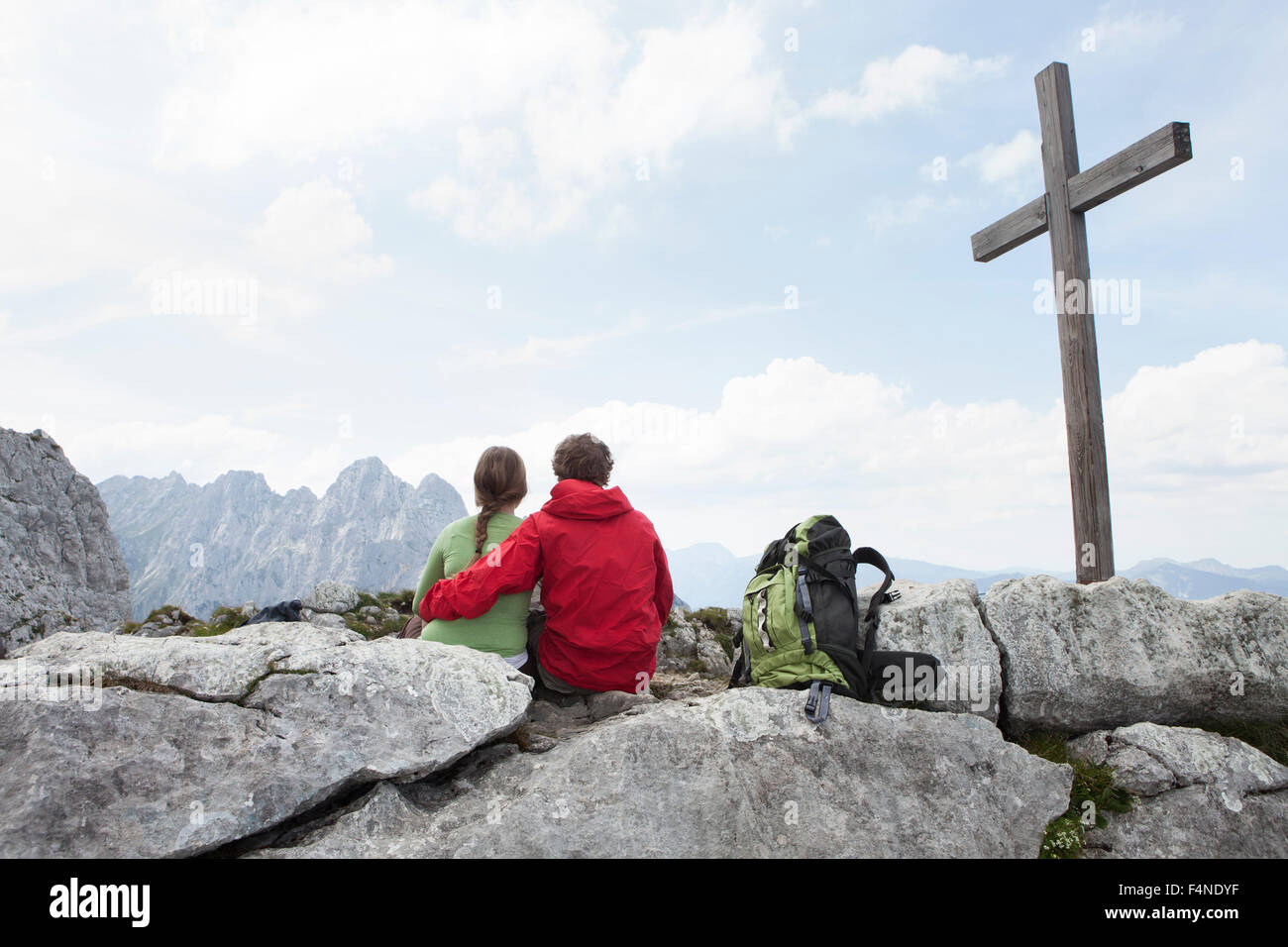 Deutschland, Bayern, Osterfelderkopf, paar ruht am Gipfelkreuz Stockfoto
