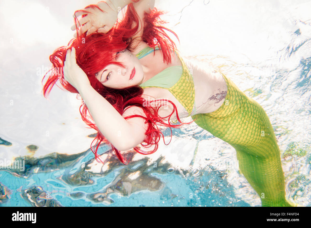 Junge Frau in der Verkleidung von Arielle, die Meerjungfrau, unter Wasser Stockfoto