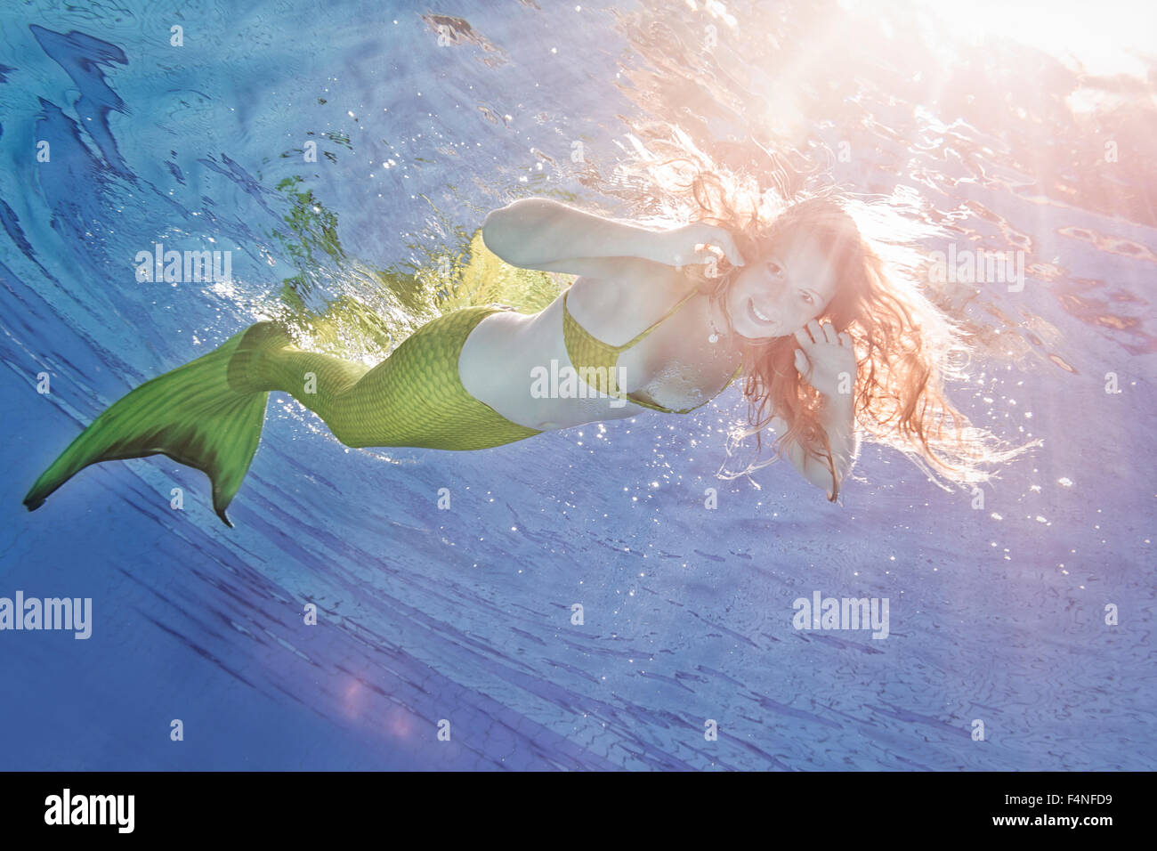 Junge Frau in der Verkleidung von Arielle, die Meerjungfrau, unter Wasser Stockfoto