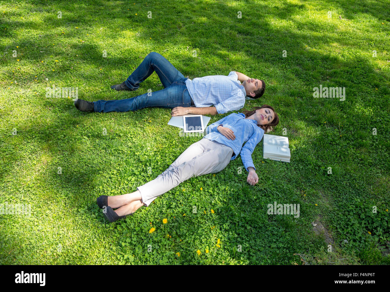 Zwei Menschen schlummern auf Rasenfläche Stockfoto