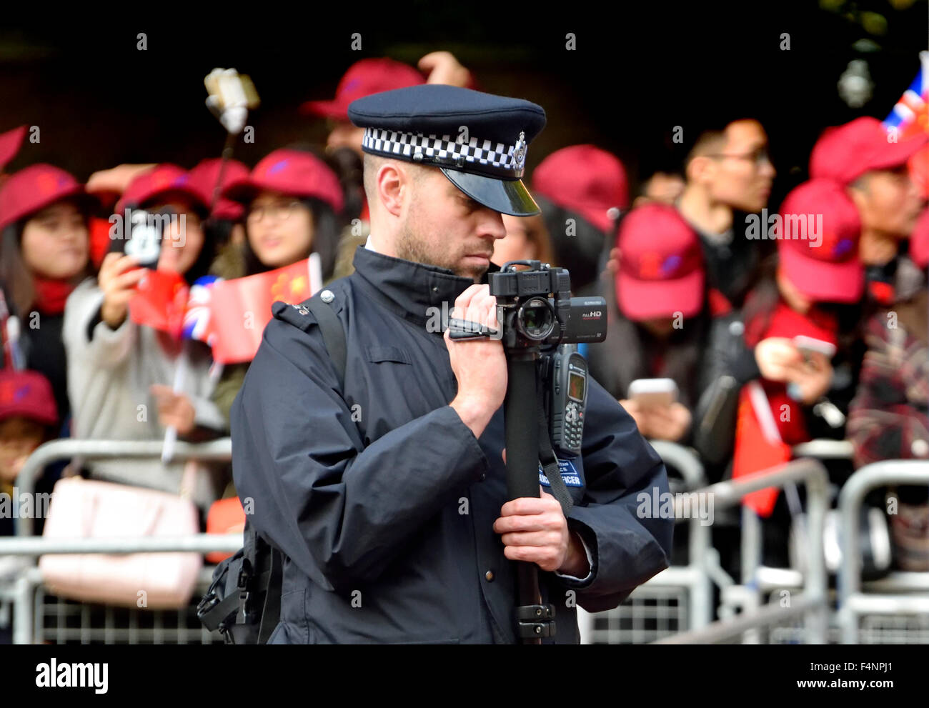 London-2015: Polizist filmt die Massen und Demonstranten bei chinesischen Staatspräsidenten Xi Jinping Besuch in London Stockfoto