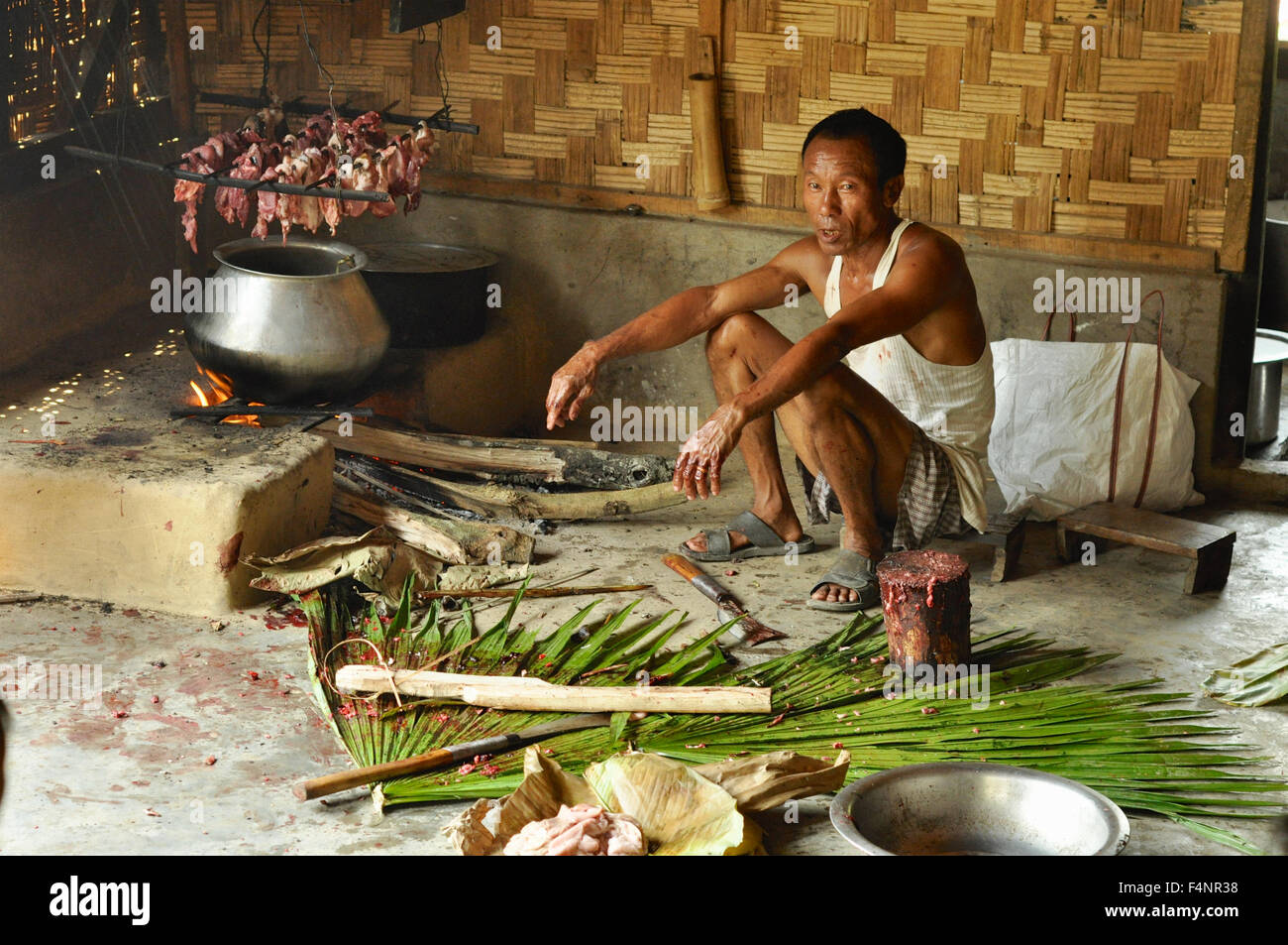 Nagaland, Indien - März 2012: Mann Kochen von Fleisch in Nagaland, abgelegenen Region von Indien. Redaktion Dokumentarfilm. Stockfoto