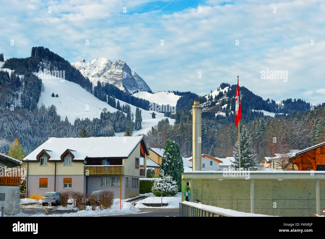 Gebäude von der Stadt Gruyères, stehend vor dem Hintergrund der schneebedeckten Schweizer Alpen. Bezirk von Gruyère im Kanton Freiburg, Schweiz Stockfoto