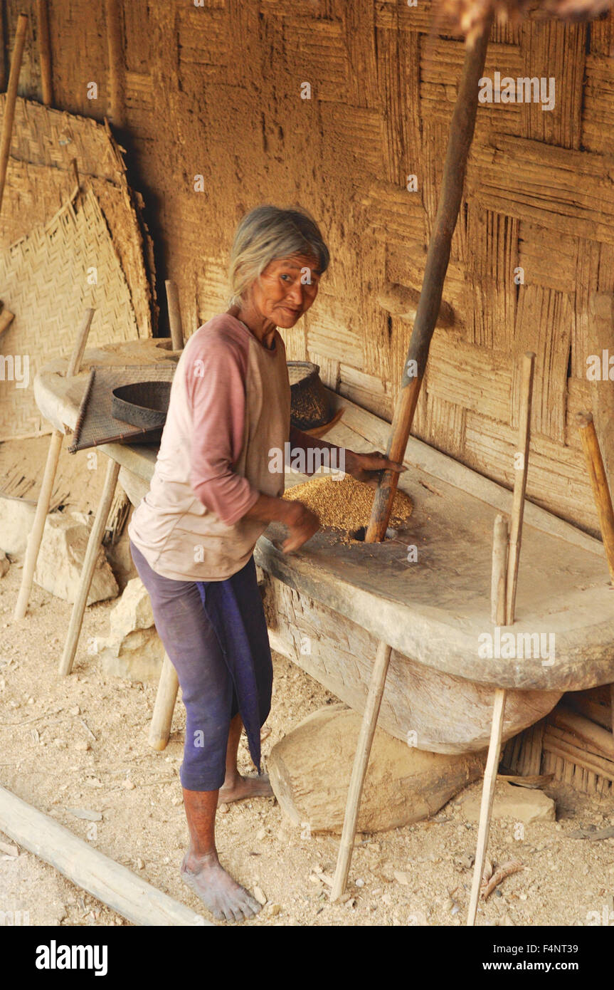Nagaland, Indien - März 2012: alte Frau mahlt Korn zu Mehl in Nagaland, abgelegenen Region von Indien. Redaktion Dokumentarfilm. Stockfoto
