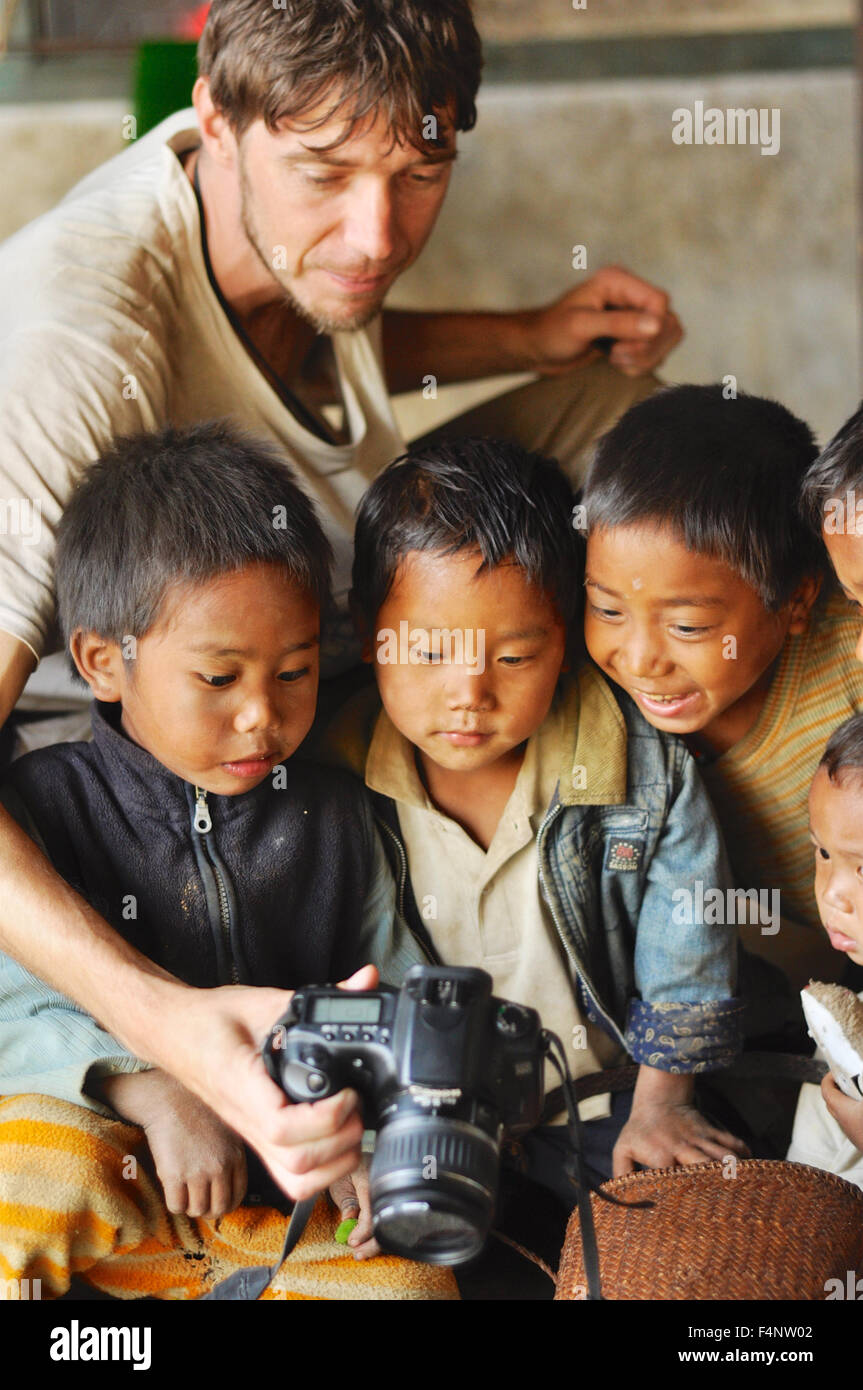 Nagaland, Indien - März 2012: Junger Fotograf zeigt Bilder auf digitale Kamera für kleine Jungen im Dorf in Nagaland, remote r Stockfoto