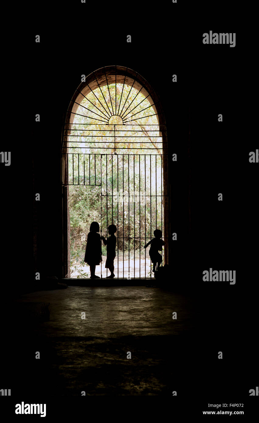Drei birmanischen Kinder Silhouette gegen einen Gate-Eingang zu einem Tempel in Bagan Myanmar Stockfoto