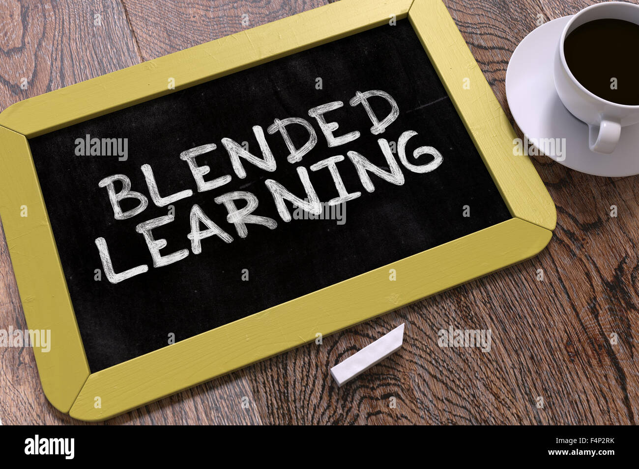 Blended-Learning handschriftlich mit weißer Kreide auf eine Tafel. Komposition mit kleinen gelben Tafel und Kaffee. Top Vie Stockfoto