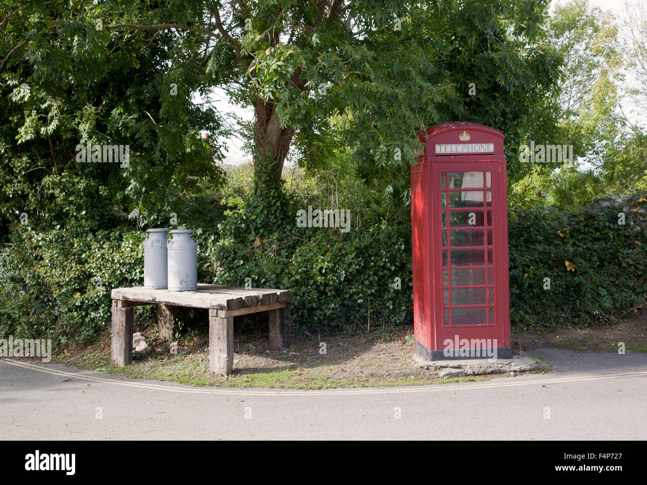 Crantock Dorf rote Telefonbox und Milch Churns, Cornwall, England, Großbritannien Stockfoto