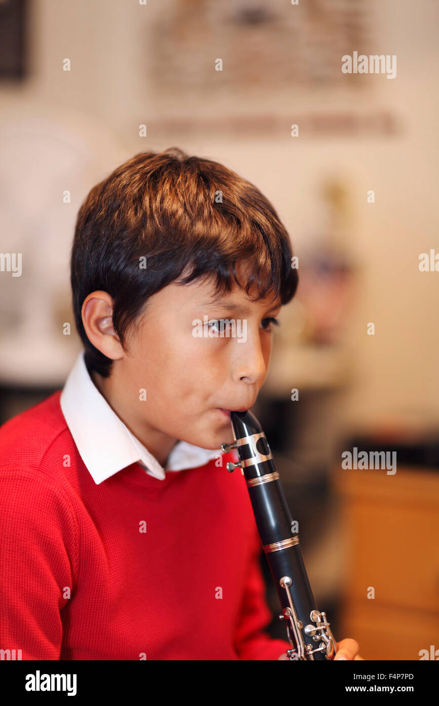 Junge - geringe Schärfentiefe - warme Tönen Klarinette zu spielen. Hochformat. Kopie Raum oben. Stockfoto