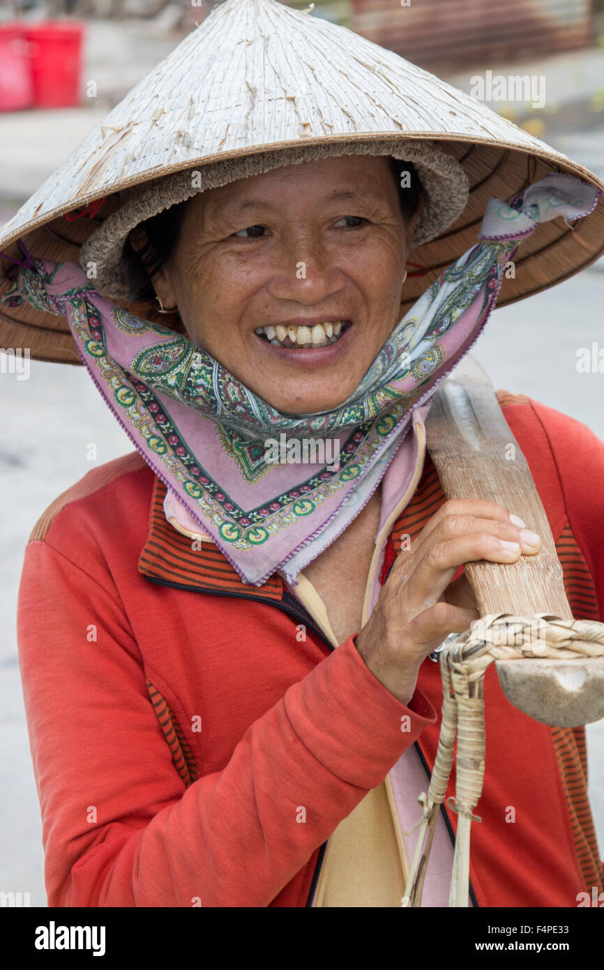 Porträtaufnahme eines Reifen vietnamesischen Dame tragen ihr Joch mit Früchten in Hoi an eine alte Stadt, Vietnam Stockfoto