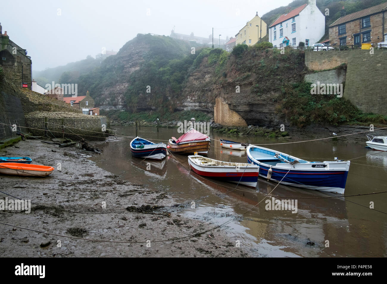 Boote vertäut am Staithes an einem nebligen Tag. Stockfoto