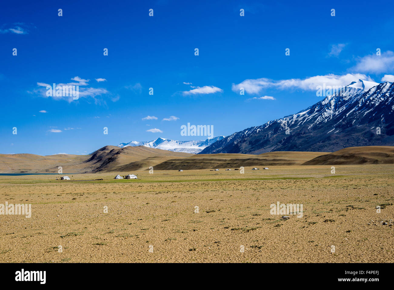 Karge Landschaft mit nomades Zelte und die schneebedeckten Berge im Bereich changtang Stockfoto
