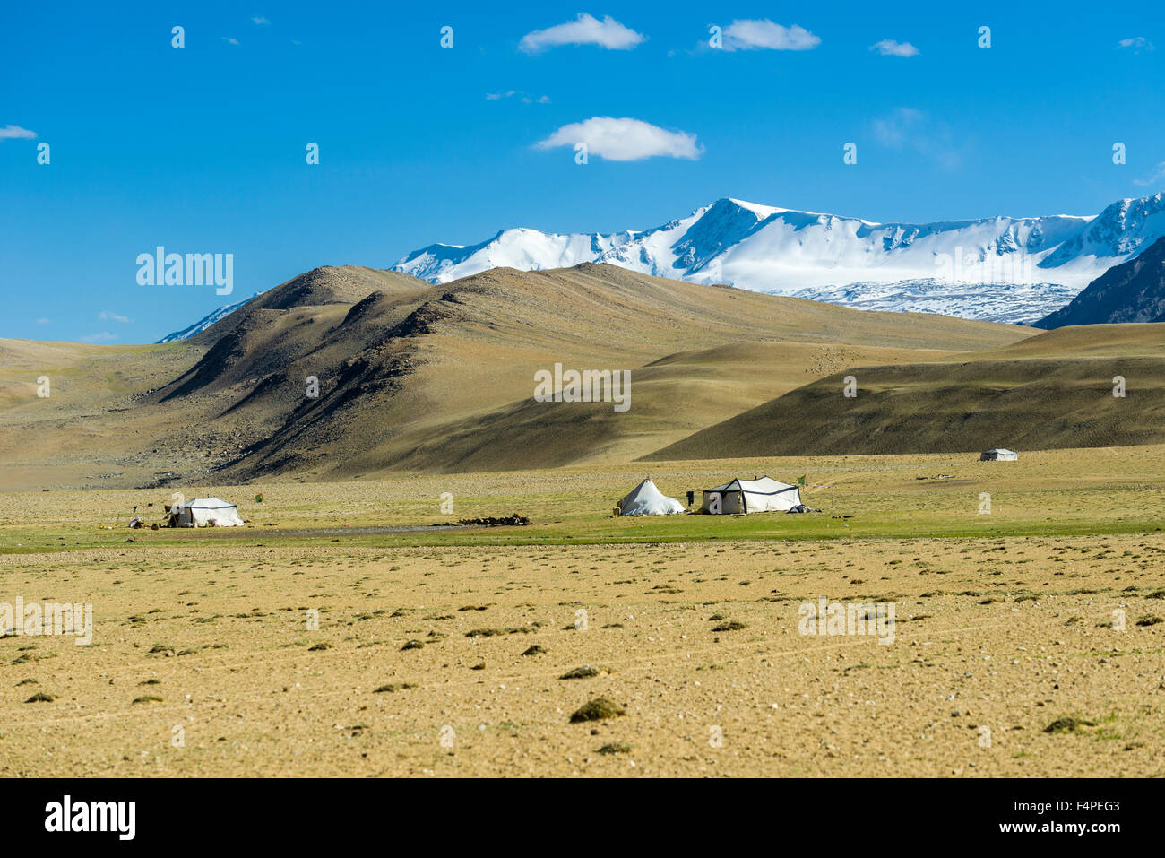 Karge Landschaft mit nomades Zelte und die schneebedeckten Berge im Bereich changtang Stockfoto