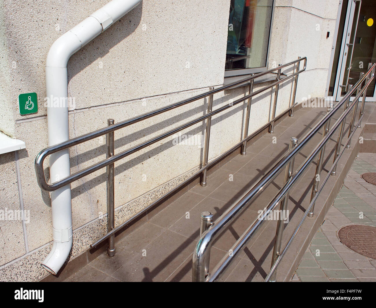 Rampe für Körperbehinderte Gäste mit Metallgeländer am Eingang eines Bürogebäudes am sonnigen Sommertag Stockfoto