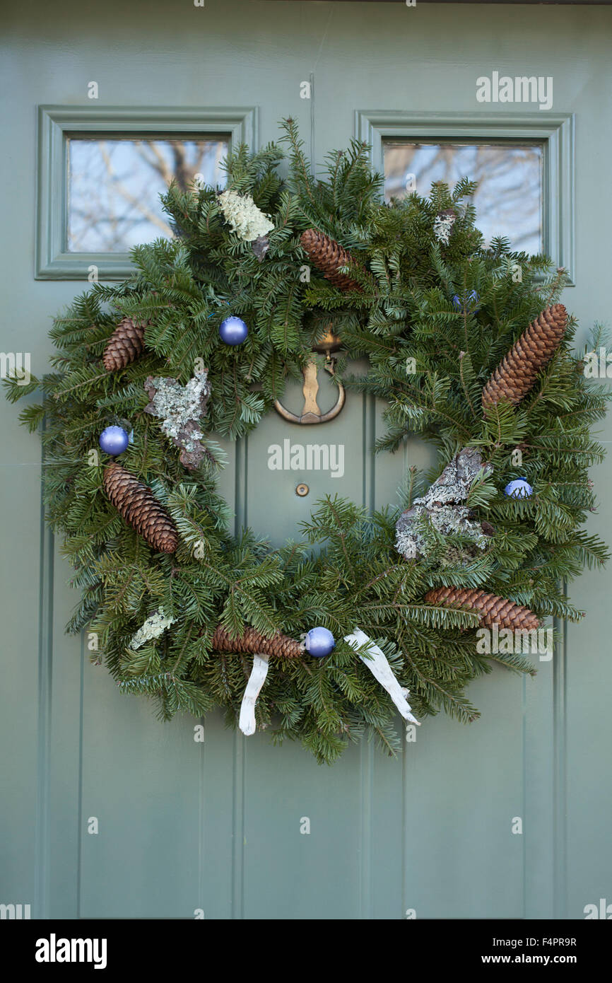 Ein Adventskranz dekoriert mit Birkenrinde, Flechten, Tannenzapfen und Glaskugeln hängt an einer Tür in den Berkshires. Stockfoto