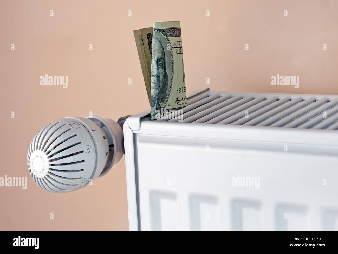 Heizung Thermostat mit Geld, hundert Dollar kostet teure Heizung Konzept Stockfoto