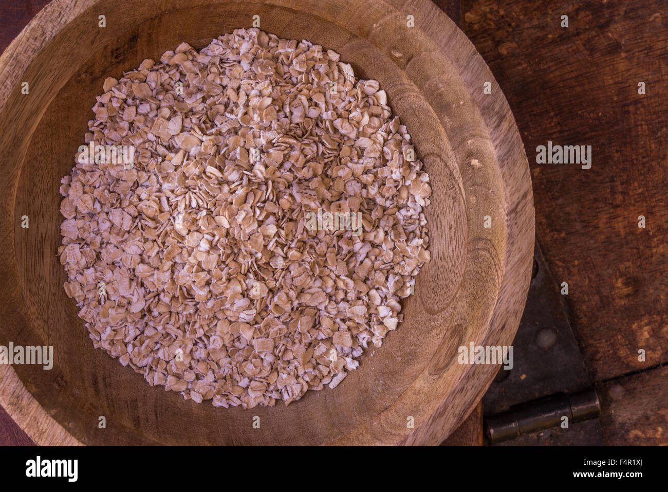Hafer in einer Holzschale auf einem antiken Tisch, gesunde Ernährung zu fördern Stockfoto