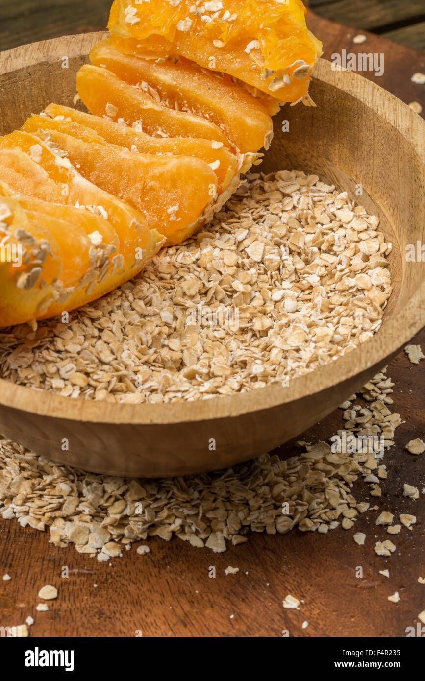 Haferflocken und eine Orange in einer Holzschale, gutes Essen zum Frühstück, vor allem, wenn der Tag richtig beginnen möchten Stockfoto