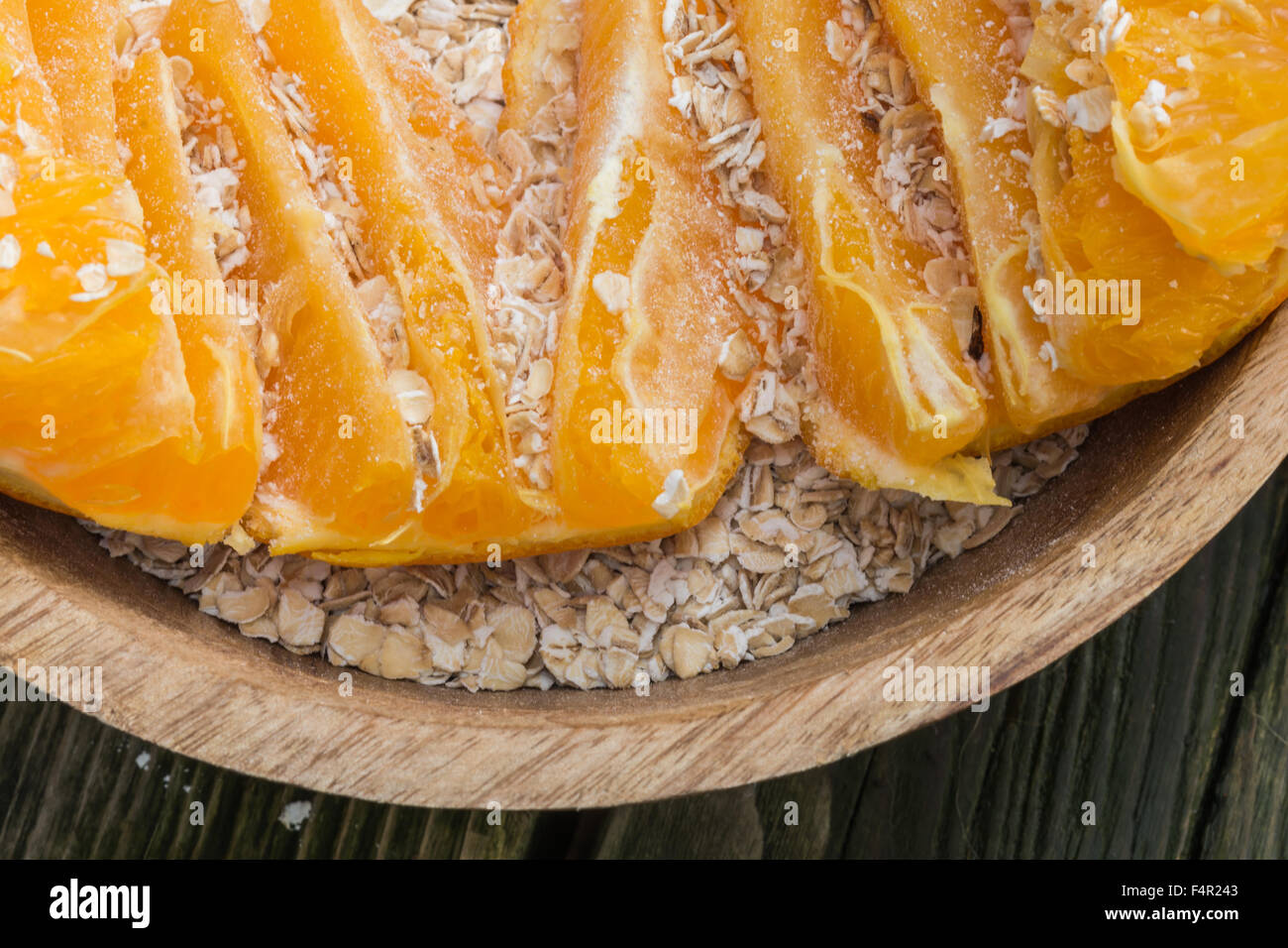 Haferflocken und Orange in einer Schüssel aus Holz, gesundes Essen zum Frühstück Start in den Tag auf eine korrekte Art groß gemacht! Stockfoto