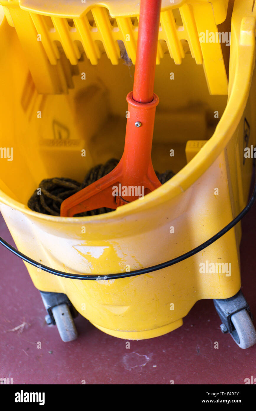 ein nasser Mopp in einem gelben Dry Mop Eimer Stockfoto