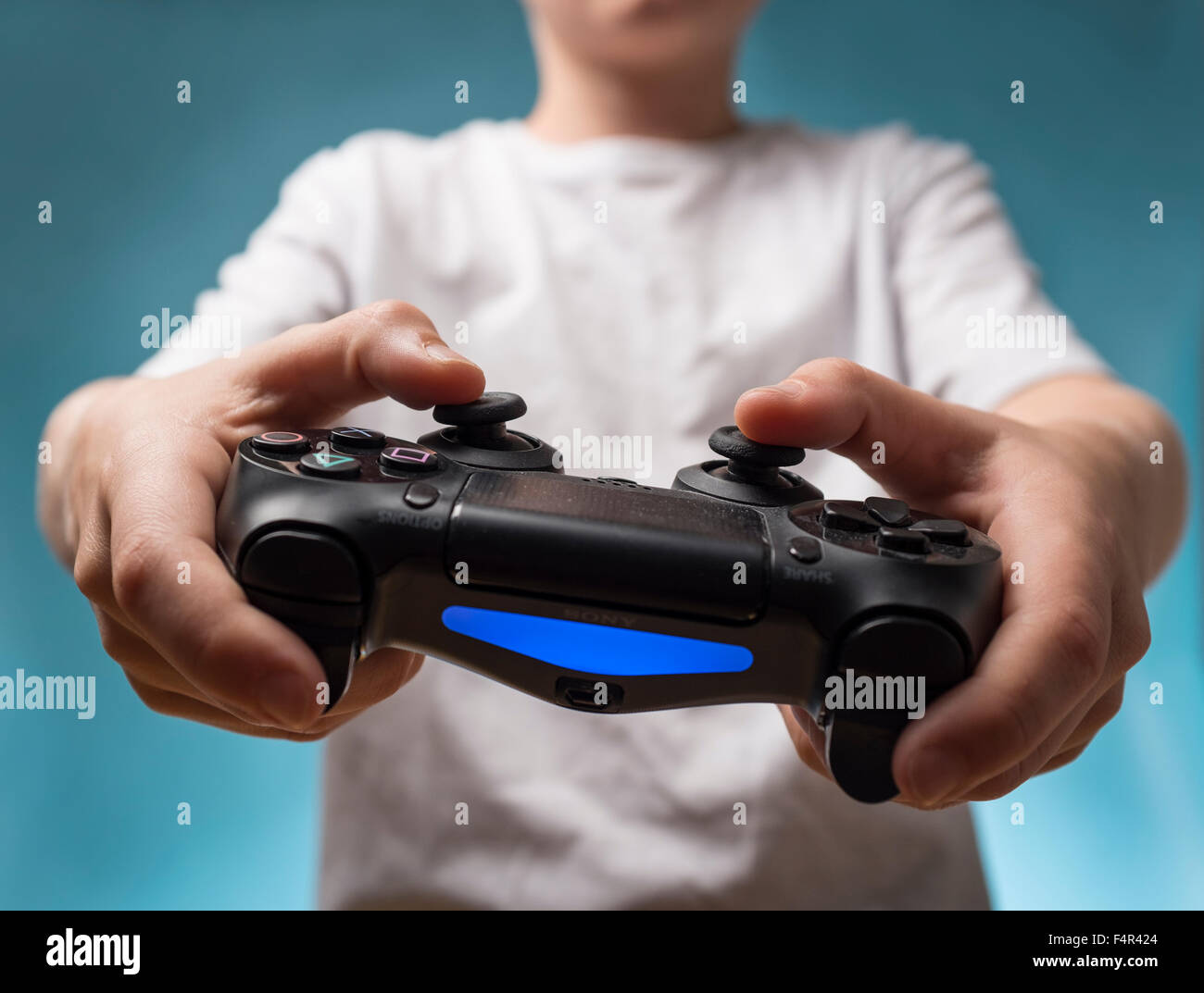 Ein Kind, das Spielen von Computerspielen mit PS4 Playstation 4 controller Stockfoto