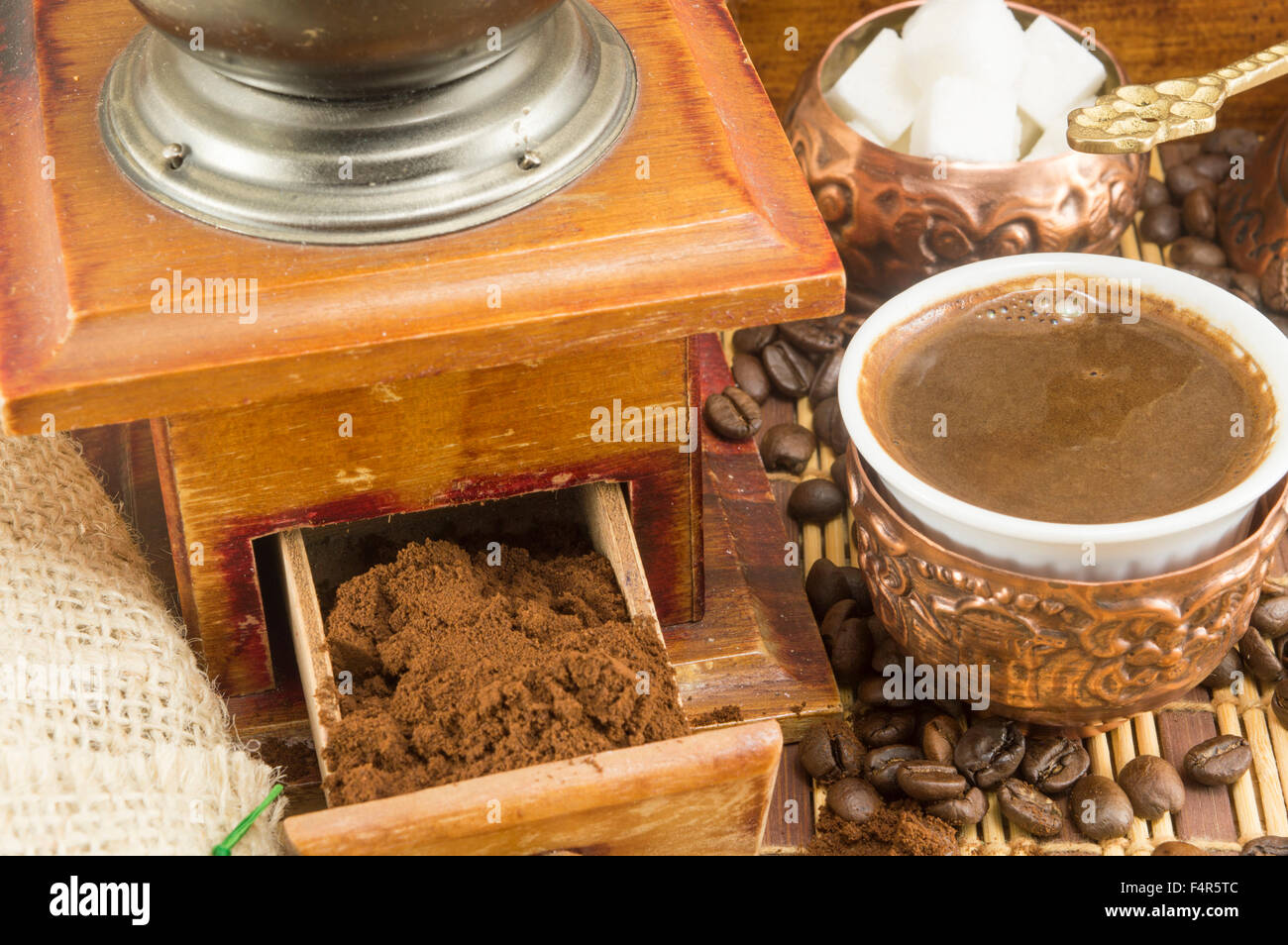 Kaffee in verschiedenen Formen rund um Oldtimer Kaffeemühle. Gemahlenen Kaffee in einer Schublade Stockfoto