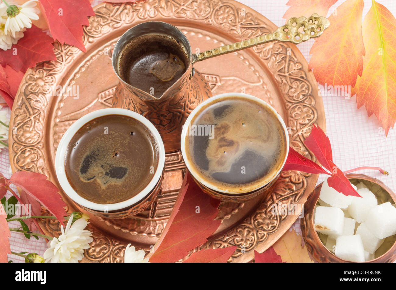 Türkischer Kaffee mit Blumen und Zucker serviert auf Kupferplatte. Stockfoto