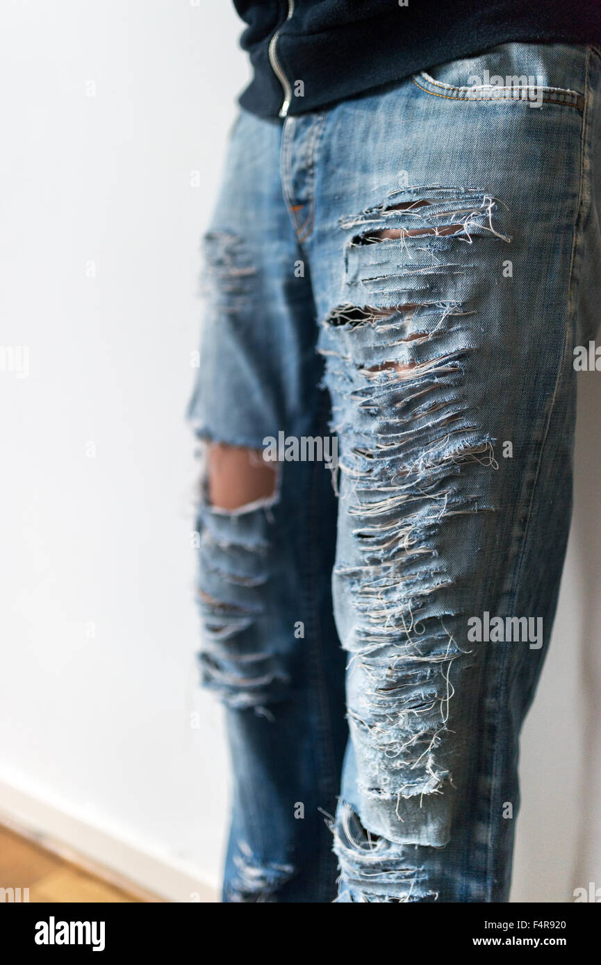 junges Mädchen schneidet ihre Jeans (MR) Stockfoto