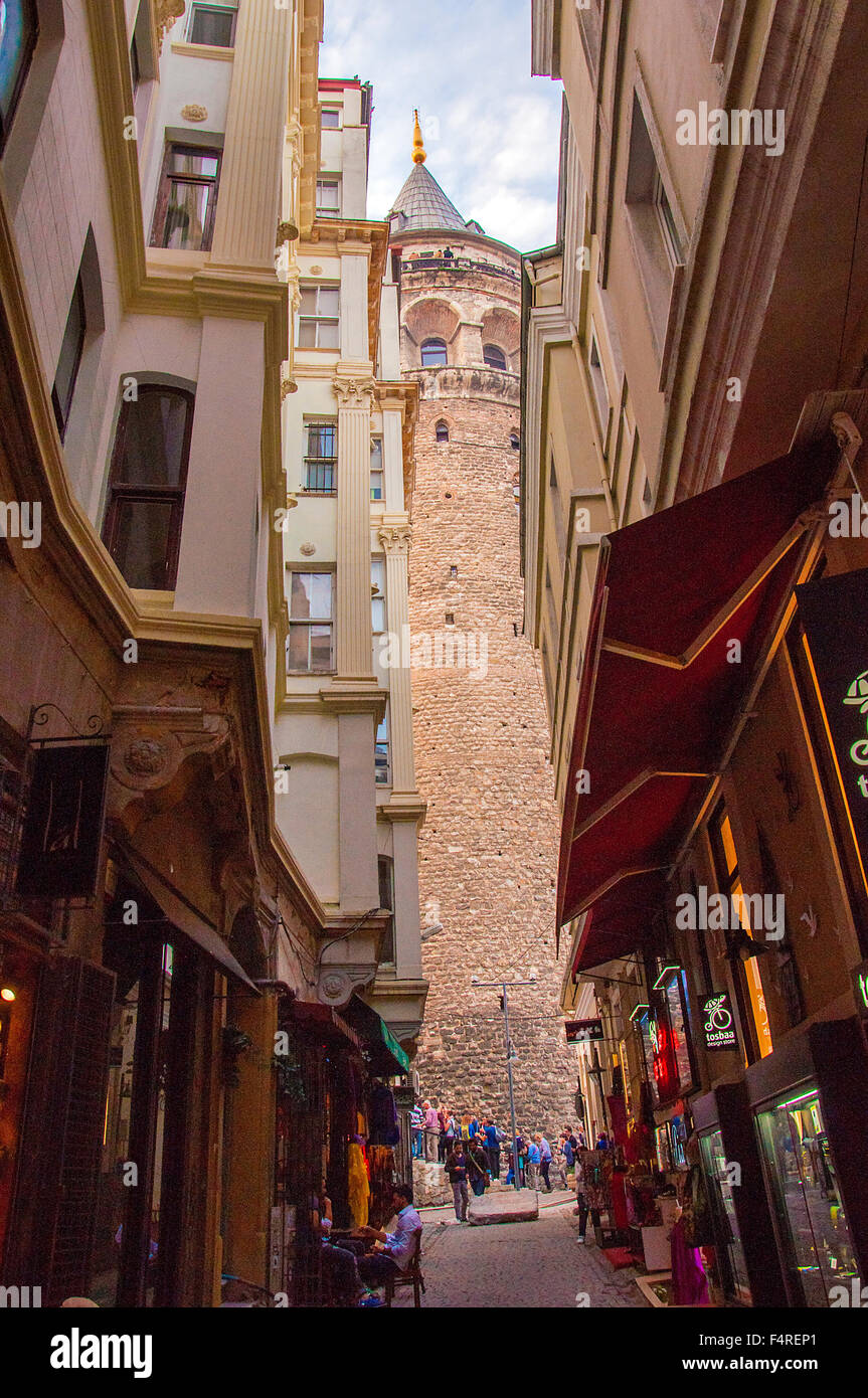 Touristen und Einheimische zu Fuß auf einer Straße zur mittelalterlichen Stein Galata-Turm - die markante Sehenswürdigkeiten in Istanbul, Türkei. Stockfoto