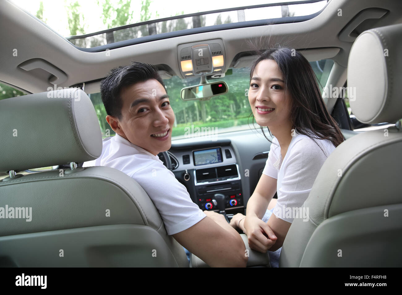 Junge Paare, die ein Auto fahren Stockfoto