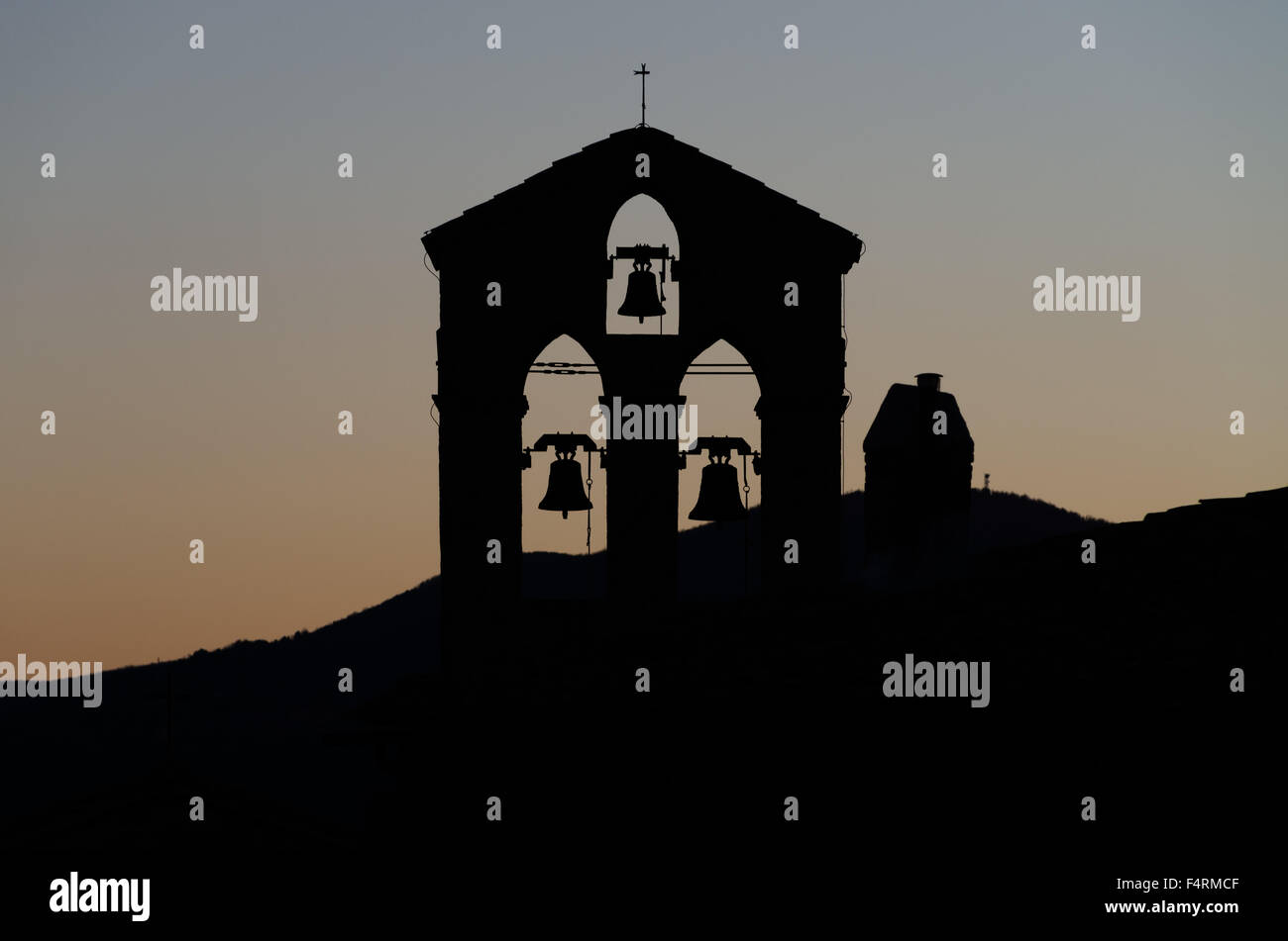Silhouette des alten Glockenturm mit einer Gruppe von drei Glocken in das Abendlicht Stockfoto