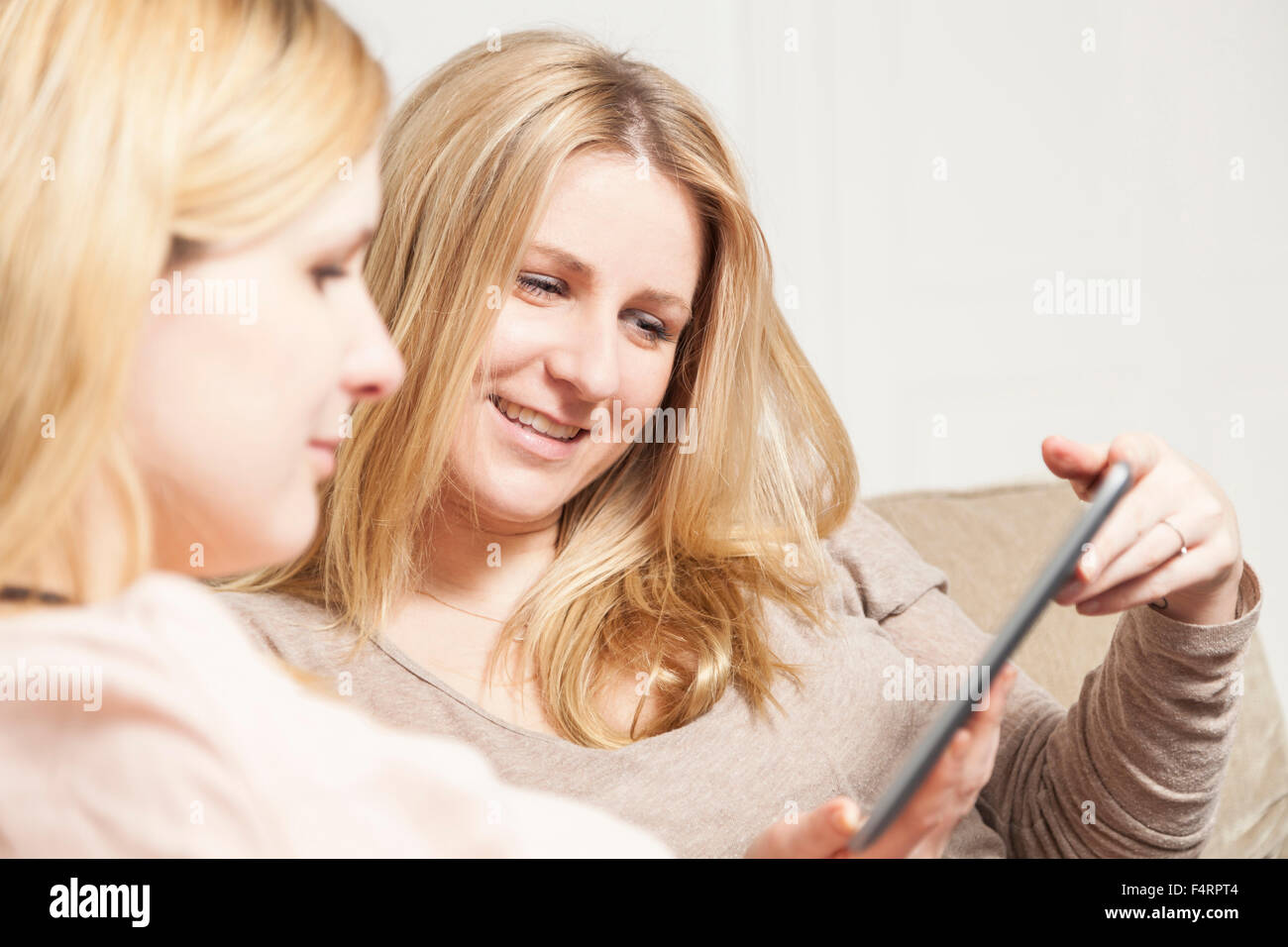 Freundinnen Blick auf tablet Stockfoto