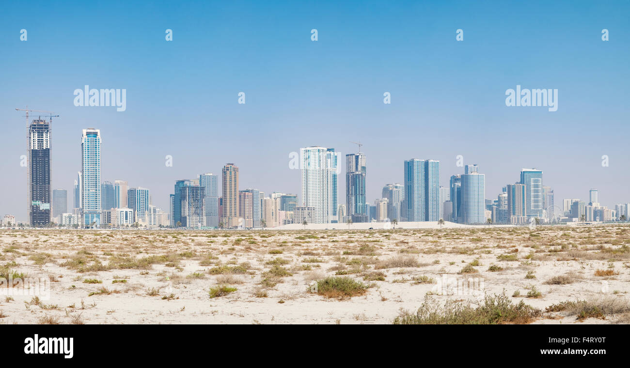 Tagsüber Skyline-Blick auf moderne Apartment-Hochhäuser aus Wüste in Sharjah, Vereinigte Arabische Emirate Stockfoto
