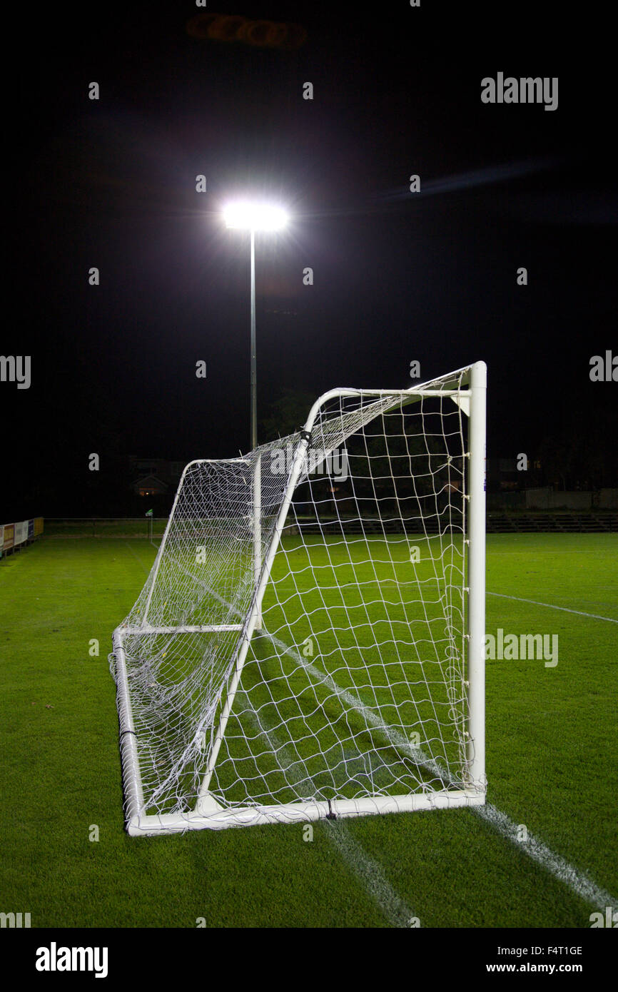 Torpfosten auf einem Fußballplatz mit Flutlicht im Hintergrund. Stockfoto