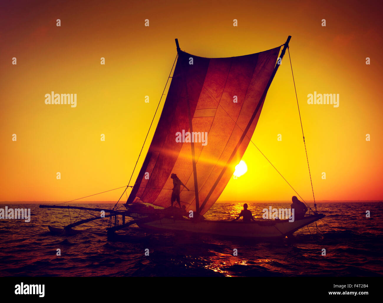 Fischer auf einem Katamaran bei Sonnenuntergang Concept Stockfoto