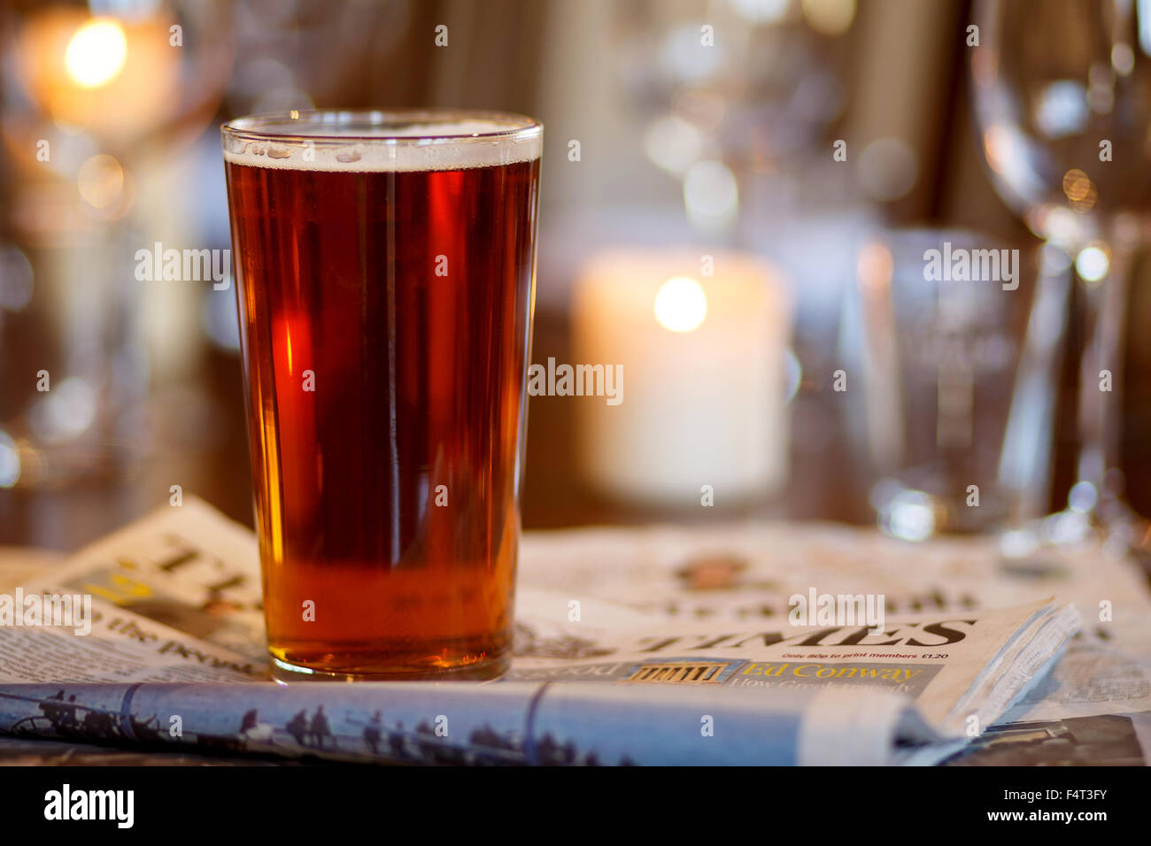 Ein Pint Bier in einer Kneipe-Tabelle mit Zeitungen Stockfoto