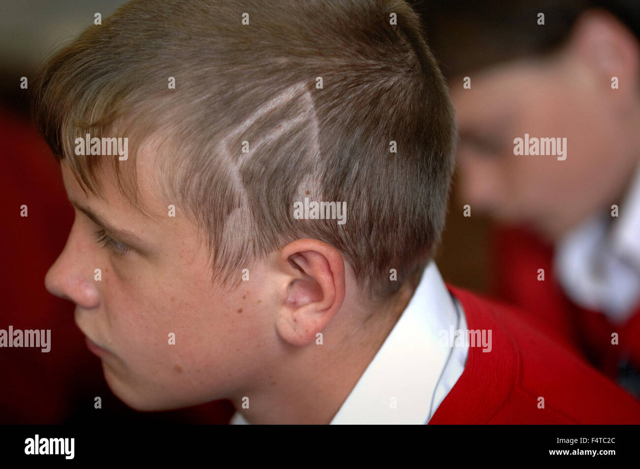 Männliche Kursteilnehmer mit einem musikalischen Hinweis rasiert in seinen Kopf, was gegen Schulpolitik und könnte ihn ausgeschlossen oder verboten. Stockfoto