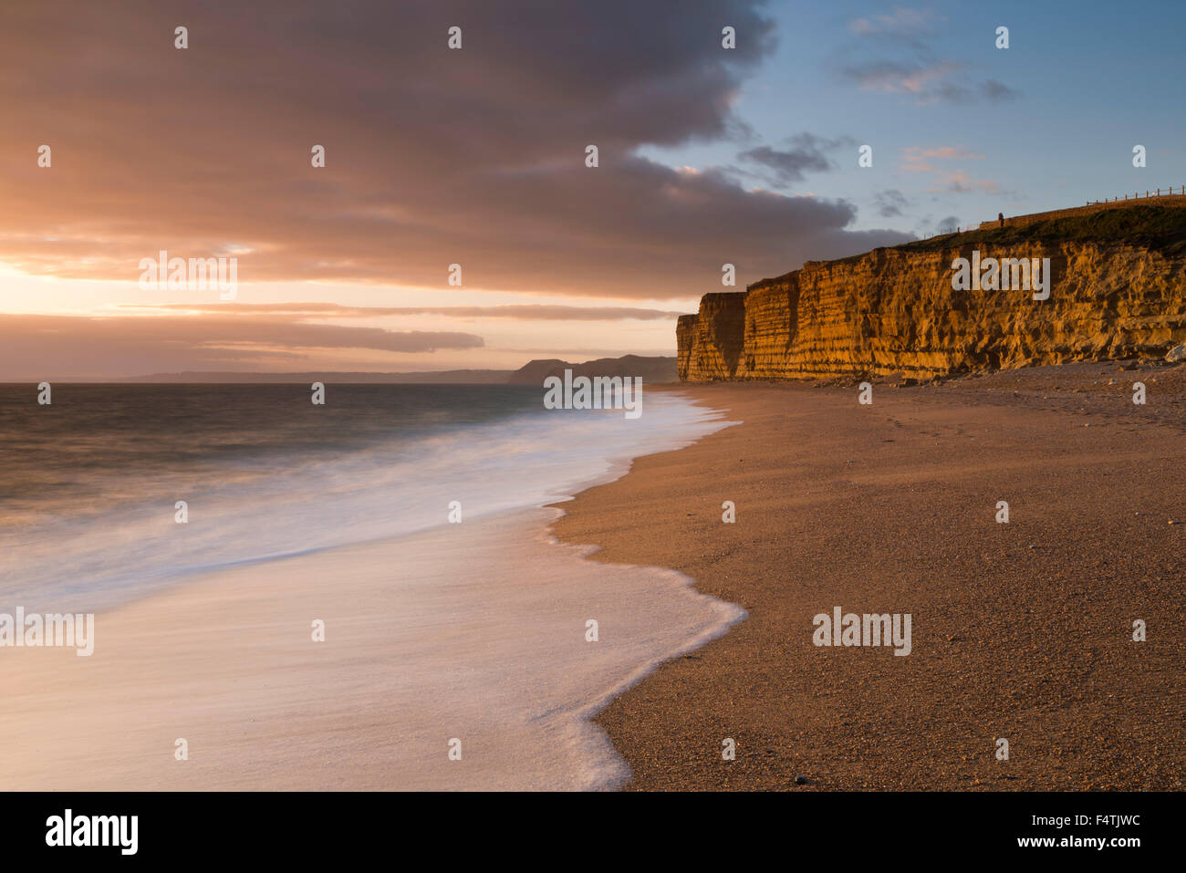 Burton Bradstock, Dorset, UK.  22. Oktober 2015. Goldene Abendlicht beleuchtet die vertikalen Sandsteinfelsen im Bienenstock Beach in Burton Bradstock auf Dorset Jurassic Coast, UK, nach einem bewölkten Tag - Bildnachweis: Graham Hunt/Alamy Live News Stockfoto