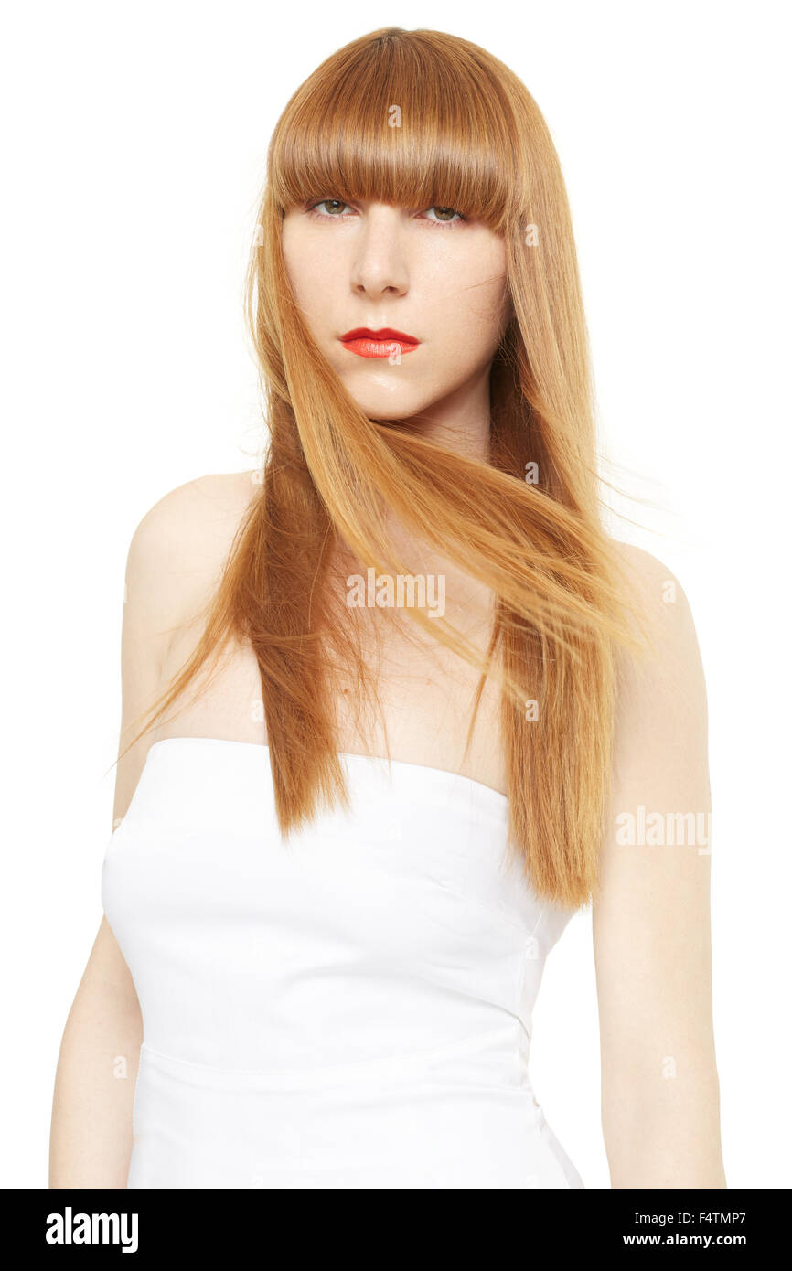 Blondes Haar. Junge Frau mit langen, geraden Haar im Wind mit Fransen auf weiß Stockfoto