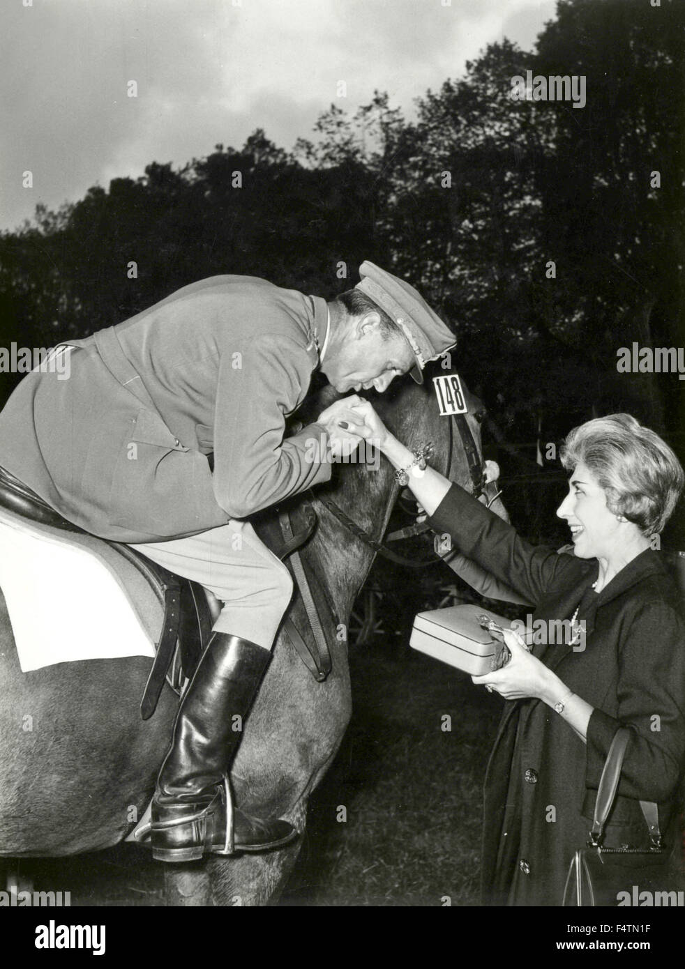 Polizist auf dem Pferderücken küsst die Hand einer Dame Stockfoto