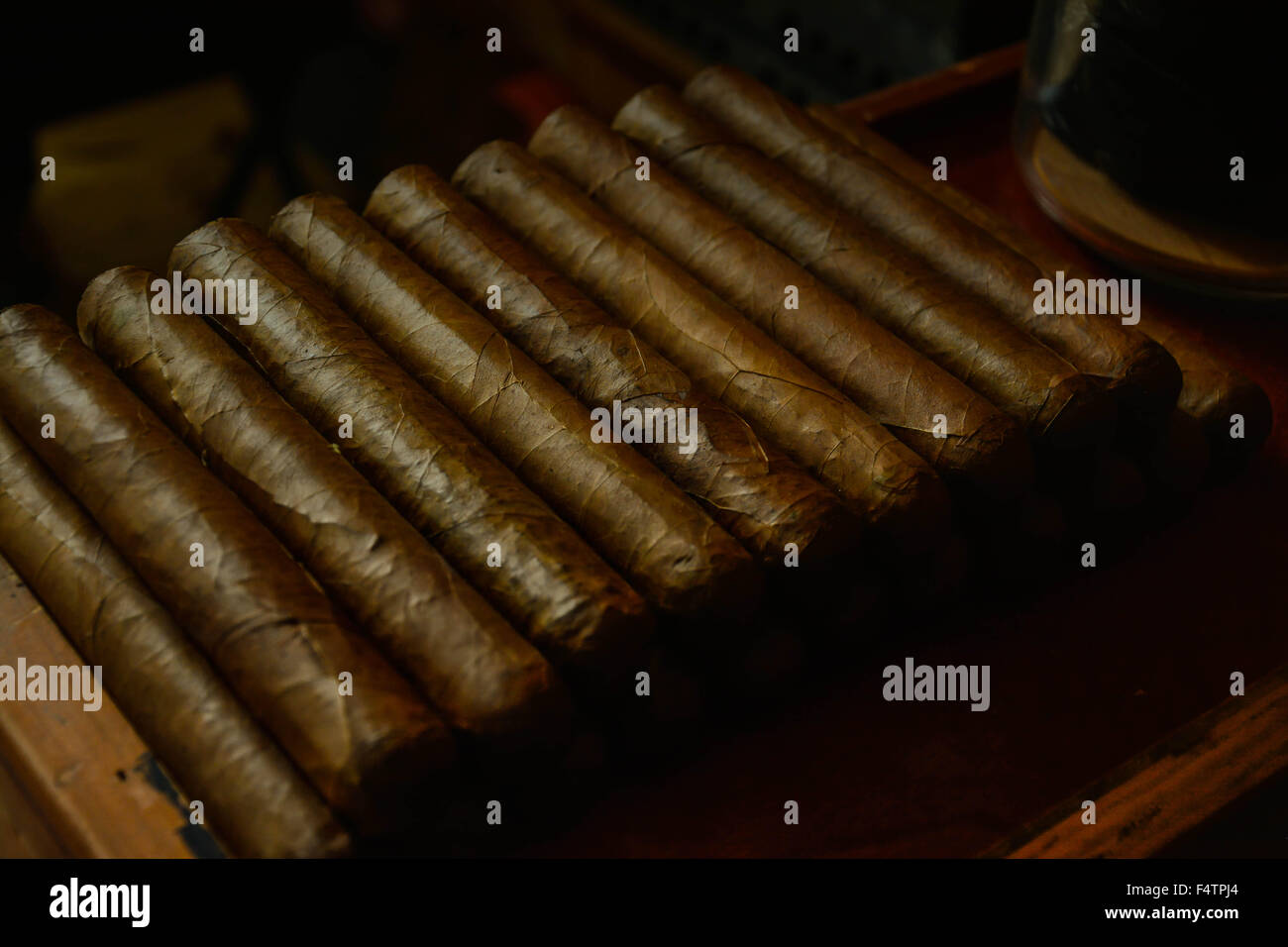 Moody, künstlerischen und nostalgischen Blick auf Hand gerollt kubanische Zigarren in Zigarre Fabrikbereich Arbeit Bank gestapelt Stockfoto