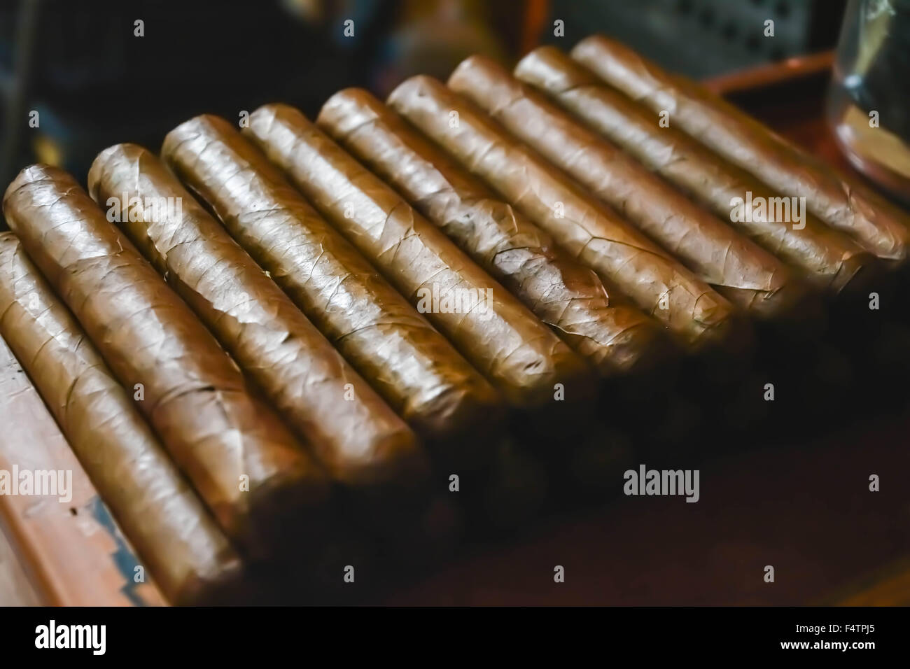 Moody, künstlerischen und nostalgischen Blick auf Hand gerollt kubanische Zigarren in Zigarre Fabrikbereich Arbeit Bank gestapelt Stockfoto