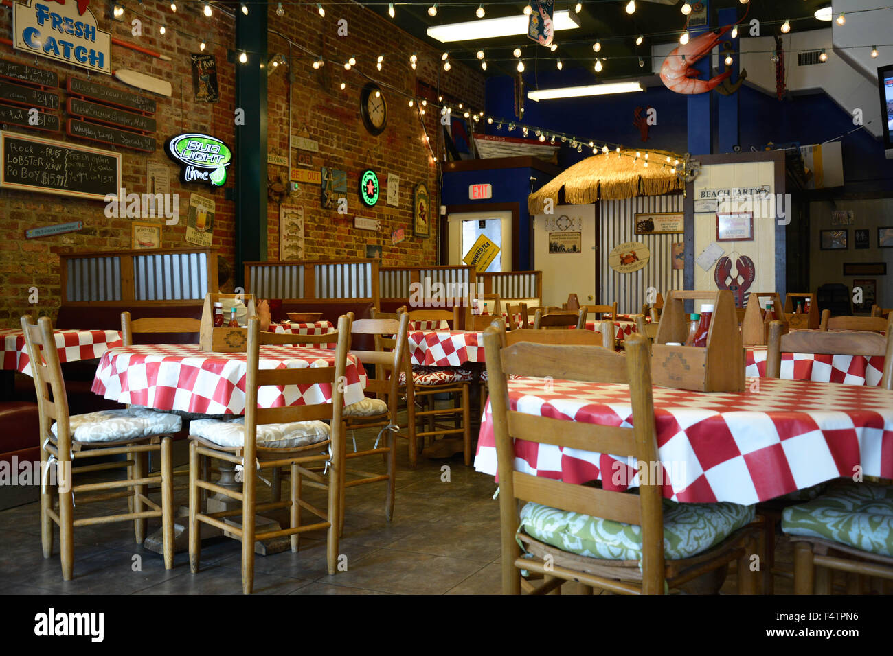Ein retro und coole alte historische rustikales Fischrestaurant mit Menüs auf der Wand Ziegel und ausgestattet mit roten & weiße Tischdecken Stockfoto