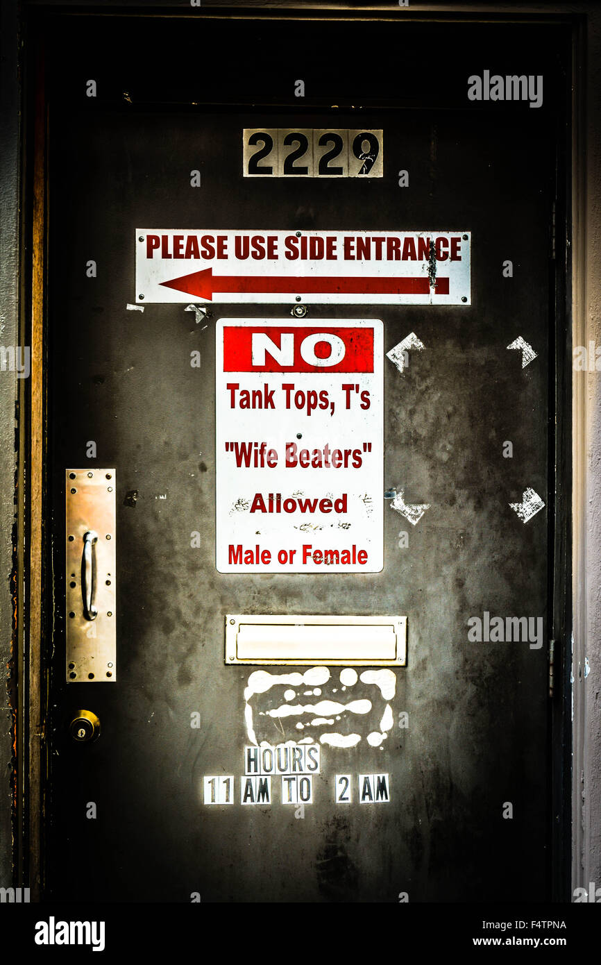 Dress-Code geschrieben am funky Beat-up Tür des Dive bar "erlaubt keine Tank-Tops, T-Shirts oder Frau Schläger, männlich oder weiblich" Stockfoto