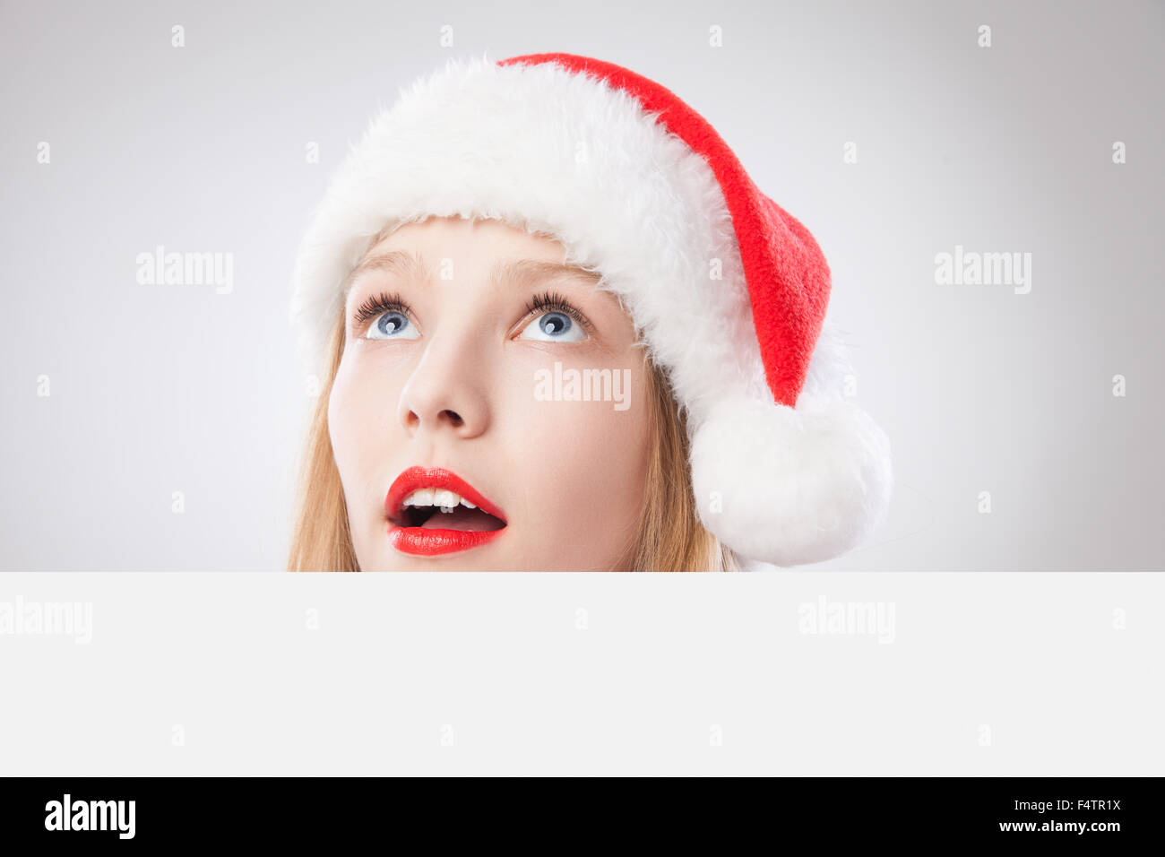 Weihnachten-Frau in Nikolausmütze mit leeren Brett Stockfoto