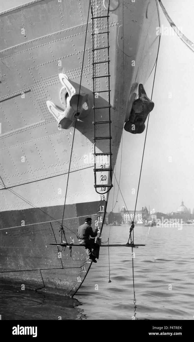 Ein Arbeiter malt ein Schiff in Kopenhagen, Dänemark Stockfoto