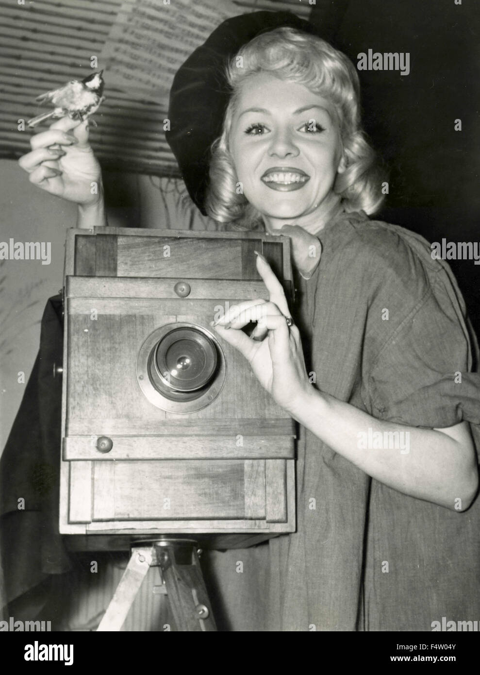 Die US-amerikanische Schauspielerin Doris Day neben einer alten Kamera lächelt Stockfoto