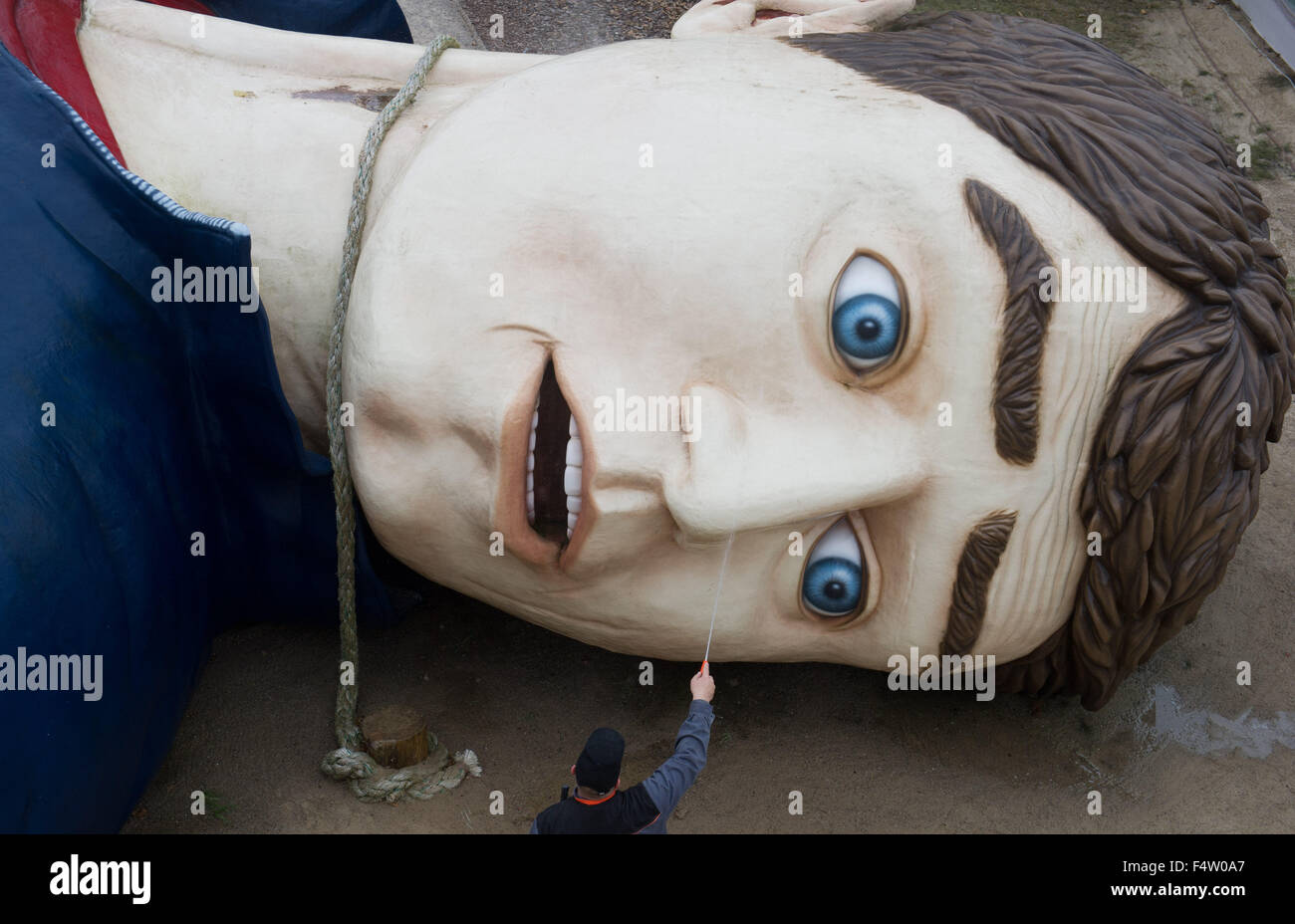 Pudagla, Deutschland. 14. Oktober 2015. Ein Arbeiter reinigt den Kopf der Figur "Gulliver" mit einem Schlauch in der "Gullivers Welt" Erlebnispark auf der Insel Usedom in Pudagla, Deutschland, 14. Oktober 2015. Die Figur muss gereinigt werden, um wetterbedingten Schäden im Winter zu vermeiden. Die Skulptur 'Gulliver in Liliput' ist 36 Meter lang und 17 Meter breit, so dass es eines der größten seiner Art in Europa. Foto: STEFAN SAUER/Dpa/Alamy Live News Stockfoto