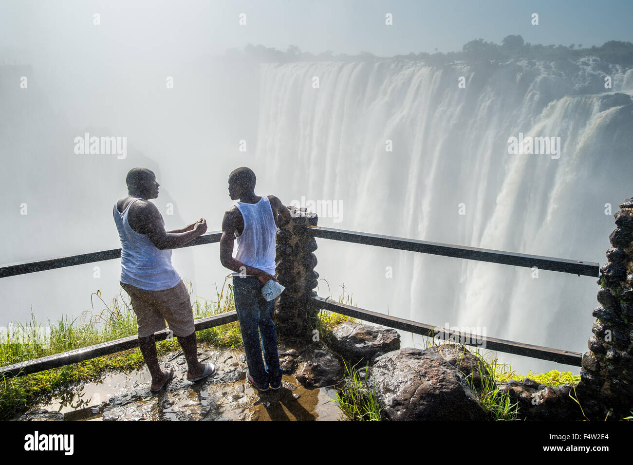 LIVINGSTONE, Sambia - zwei afrikanische Männer gegenüber den Victoria Falls Wasserfall. Stockfoto