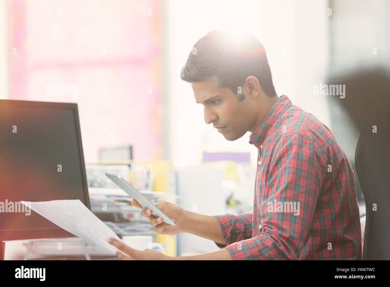 Konzentrierte sich Geschäftsmann mit digital-Tablette Überprüfung Papierkram am Schreibtisch im Büro Stockfoto
